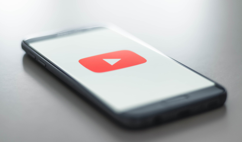A mobile phone with YouTube icon on screen