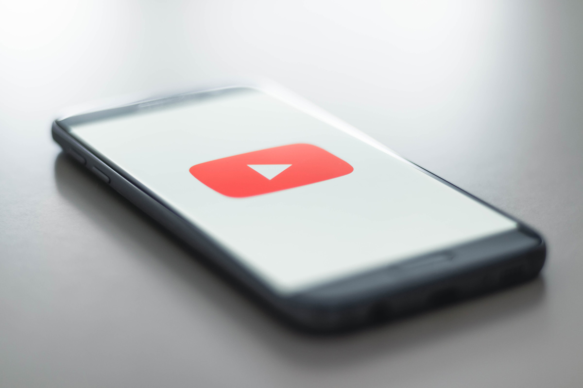 A mobile phone with YouTube icon on screen
