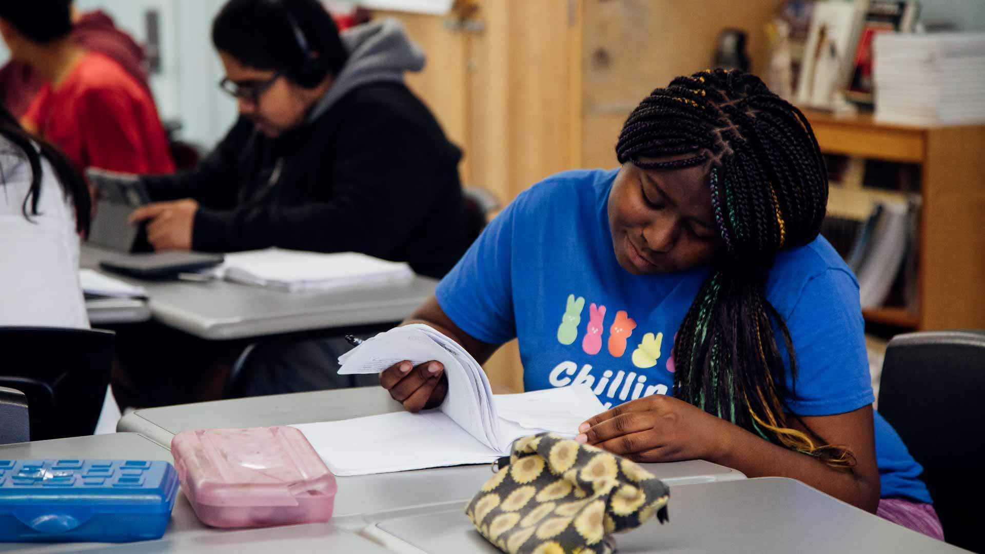 student sitting at a table looking over papers