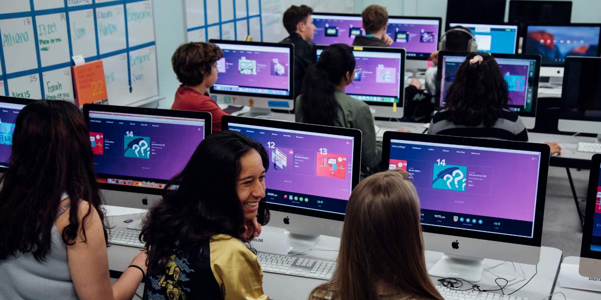 Photo of a high school classroom computer lab, featuring Checkology on the screens