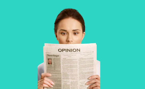 A woman reads the opinion section of a newspaper.