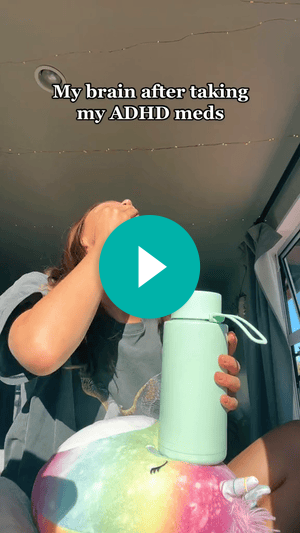 A screenshot of a video of a woman sitting in her car with her head back and holding a water bottle. Text says, “My brain after taking my ADHD meds.” A teal play button is over the woman’s neck.