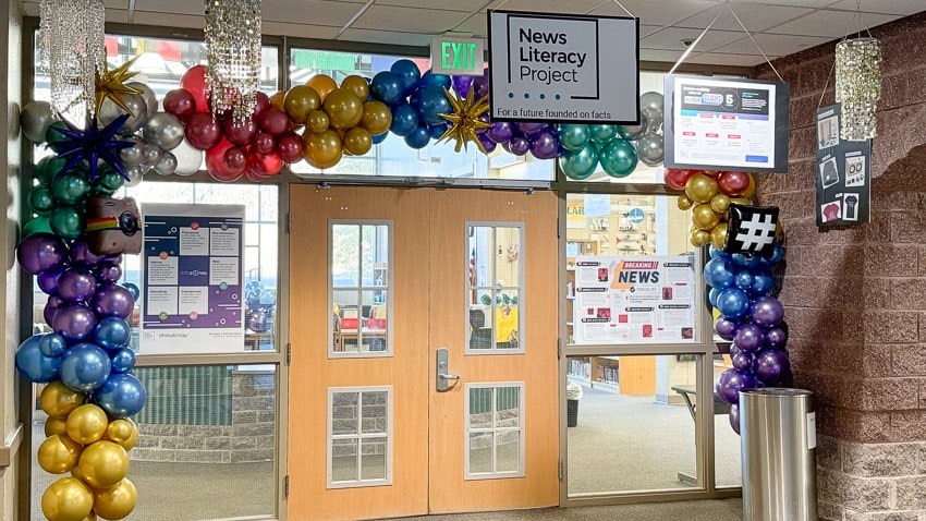 A colorful balloon archway and small chandeliers hang over the doorway to the Crested Butte Community School library.