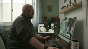 Photo of John Silva working at his desk as he works with his team on the NewsLitNation Professional Learning platform.