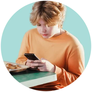 social-mediateen-survey-min-800x800 - The News Literacy Project A teen with blond hair looks down at a cell phone in his hands.